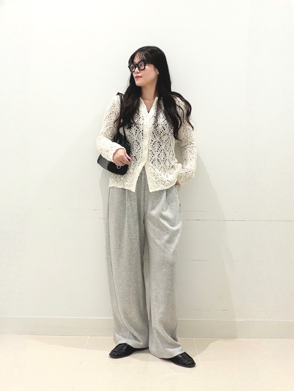 グレー系のその他パンツ、ホワイト系のニット/セーター、ブラック系のボストンバッグを着用したレディースの秋コーディネートの4枚目の写真