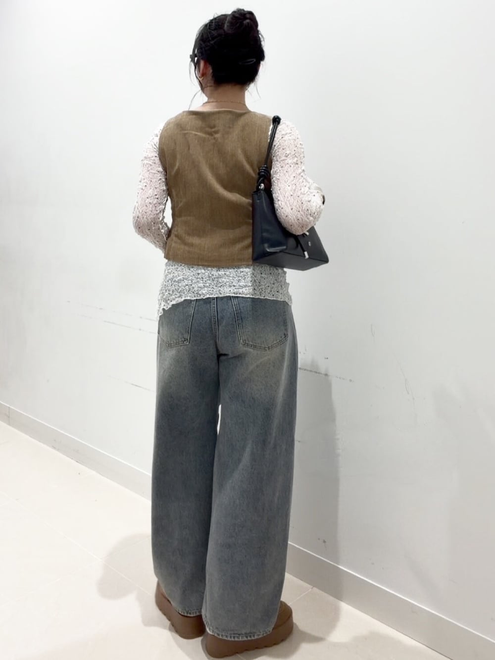 ホワイト系のTシャツ/カットソー、ベージュ系のダウンベスト、ホワイト系のキャミソールを着用したレディースの秋コーディネートの4枚目の写真