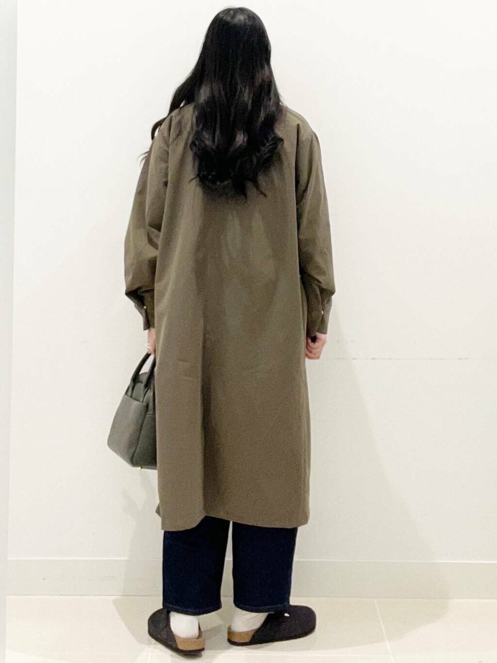 グリーン系のボストンバッグ、ブルー系のデニムパンツ、ブラウン系のその他アウターを着用したレディースの秋コーディネートの6枚目の写真