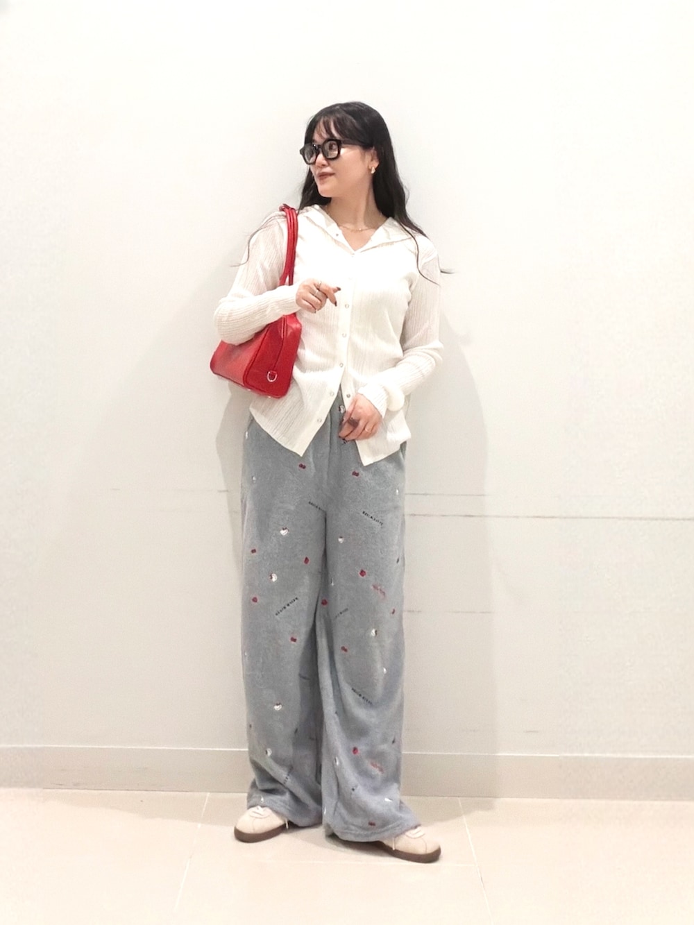 ホワイト系のニット/セーター、グレー系のその他パンツ、レッド系のボストンバッグを着用したレディースの秋コーディネートの2枚目の写真