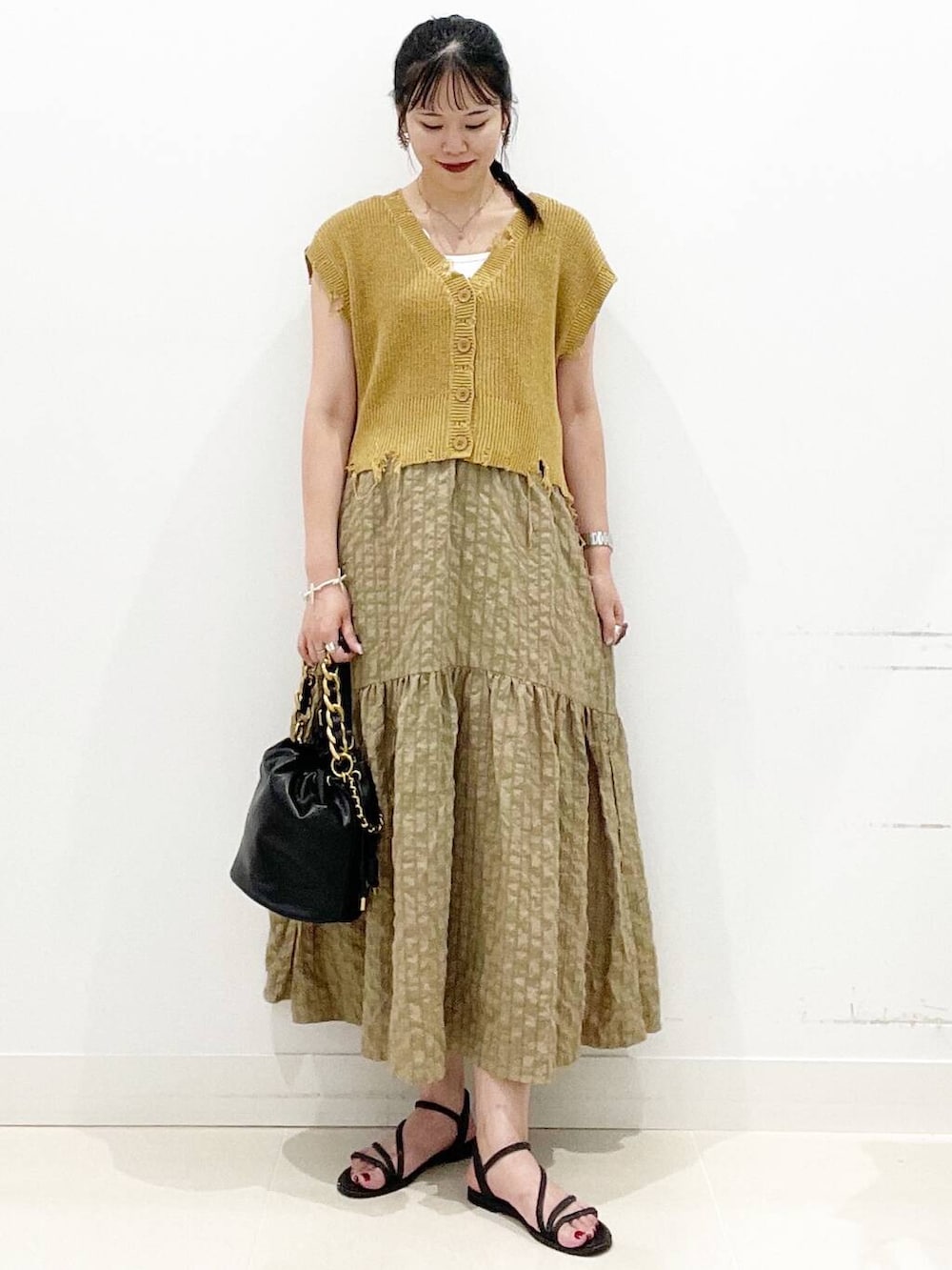 ホワイト系のキャミソール、グリーン系のスカート、ブラック系のサンダルを着用したレディースの夏コーディネートの5枚目の写真