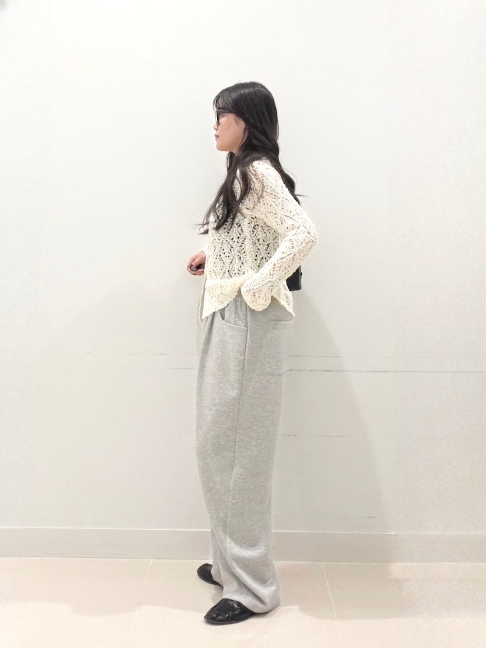 グレー系のその他パンツ、ホワイト系のニット/セーター、ブラック系のボストンバッグを着用したレディースの秋コーディネートの5枚目の写真