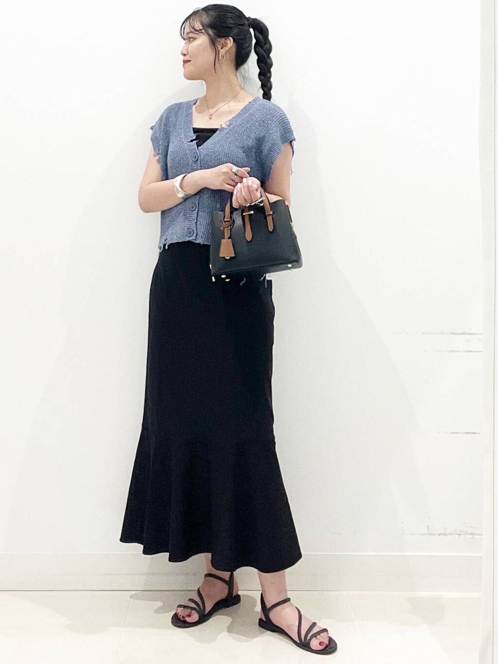 ブラック系のハンドバッグ、ブラック系のキャミソール、ブラック系のサンダルを着用したレディースの夏コーディネートの2枚目の写真