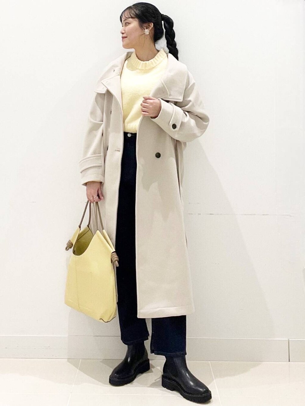 ブラック系のブーツ、ベージュ系のその他アウター、ブルー系のデニムパンツを着用したレディースの冬コーディネートの2枚目の写真