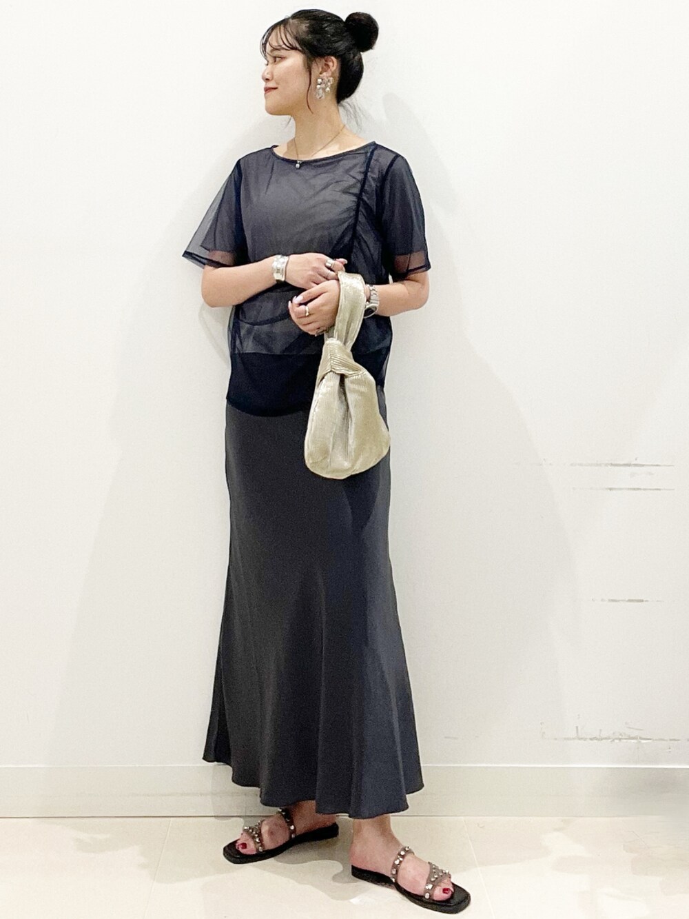 ブラック系のサンダル、ゴールド系のハンドバッグ、ブルー系のTシャツ/カットソーを着用したレディースの夏コーディネートの2枚目の写真