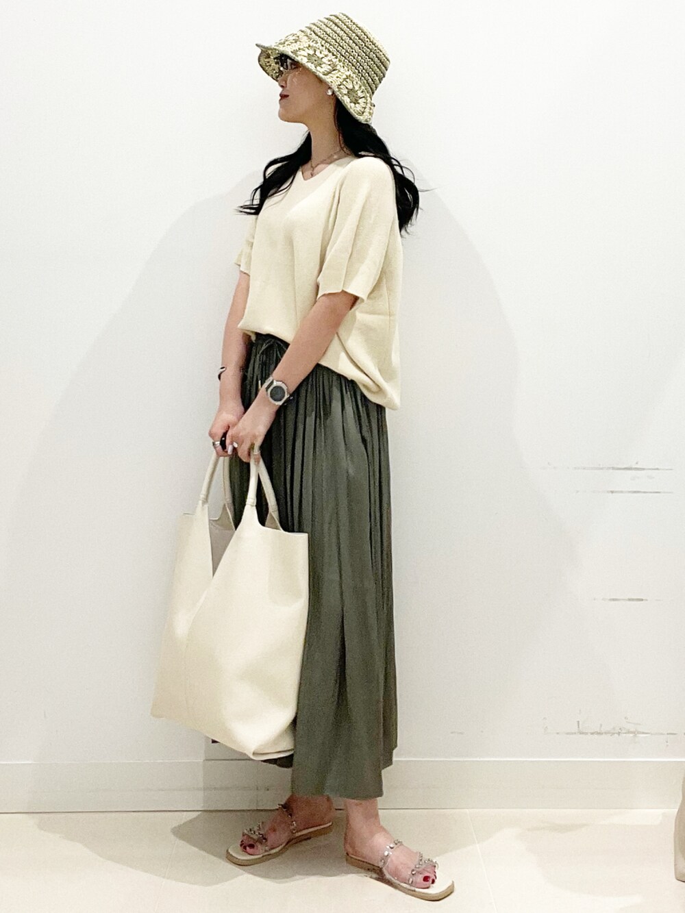ホワイト系のトートバッグ、グリーン系のその他パンツ、ホワイト系のサンダルを着用したレディースの夏コーディネートの3枚目の写真