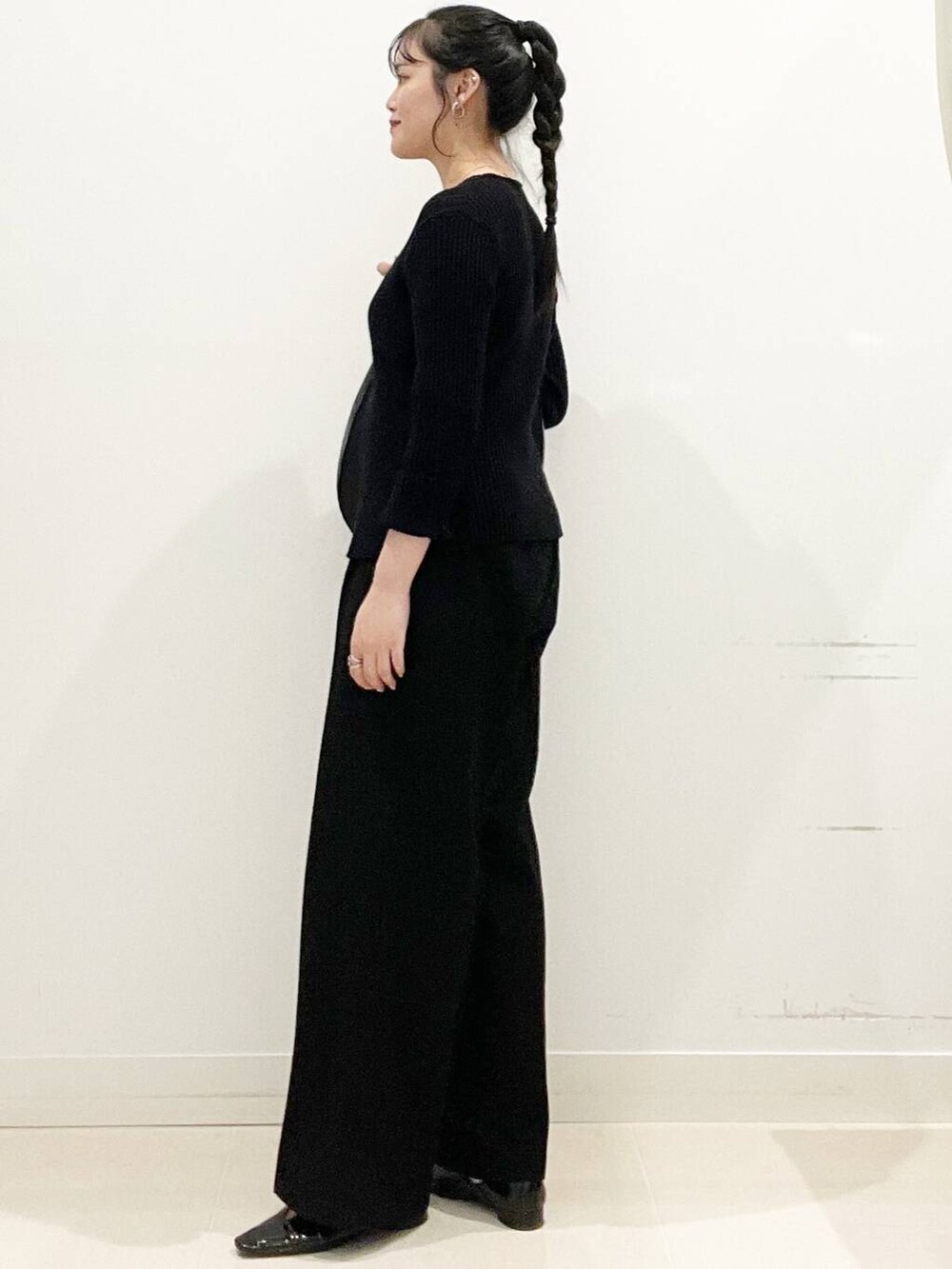 ブラック系のその他パンツ、ブラック系のショルダーバッグ、ブラック系のニット/セーターを着用したレディースの春コーディネートの7枚目の写真