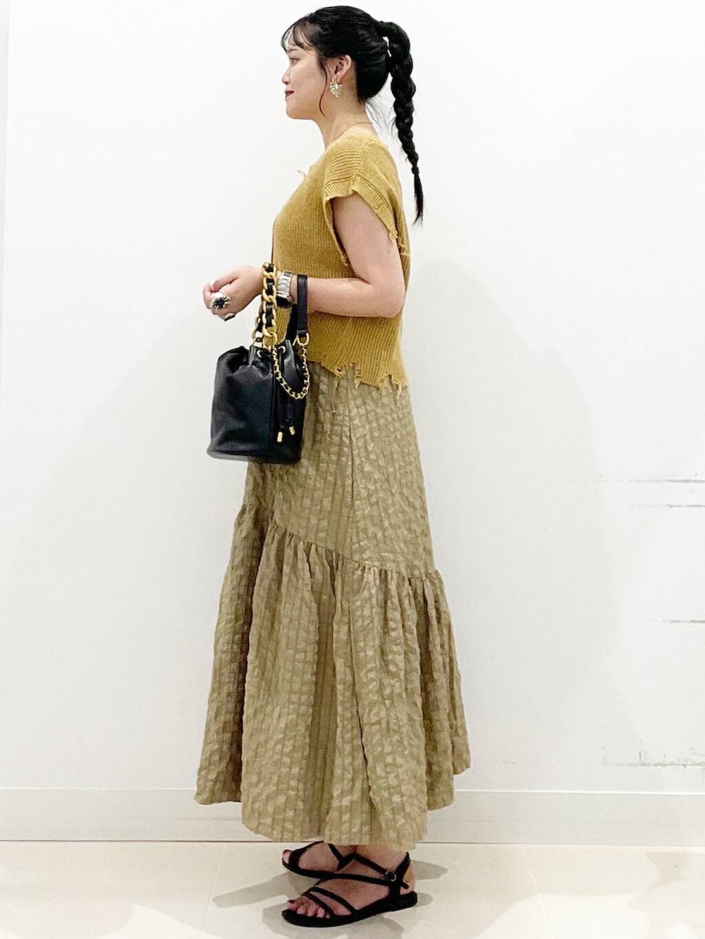 ホワイト系のキャミソール、グリーン系のスカート、ブラック系のサンダルを着用したレディースの夏コーディネートの7枚目の写真