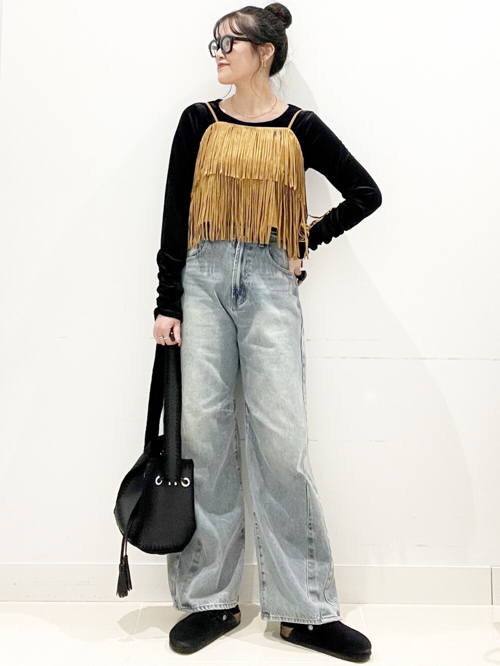 ブラック系のサンダル、ブラック系のショルダーバッグ、ブルー系のデニムパンツを着用したレディースの秋コーディネートの3枚目の写真