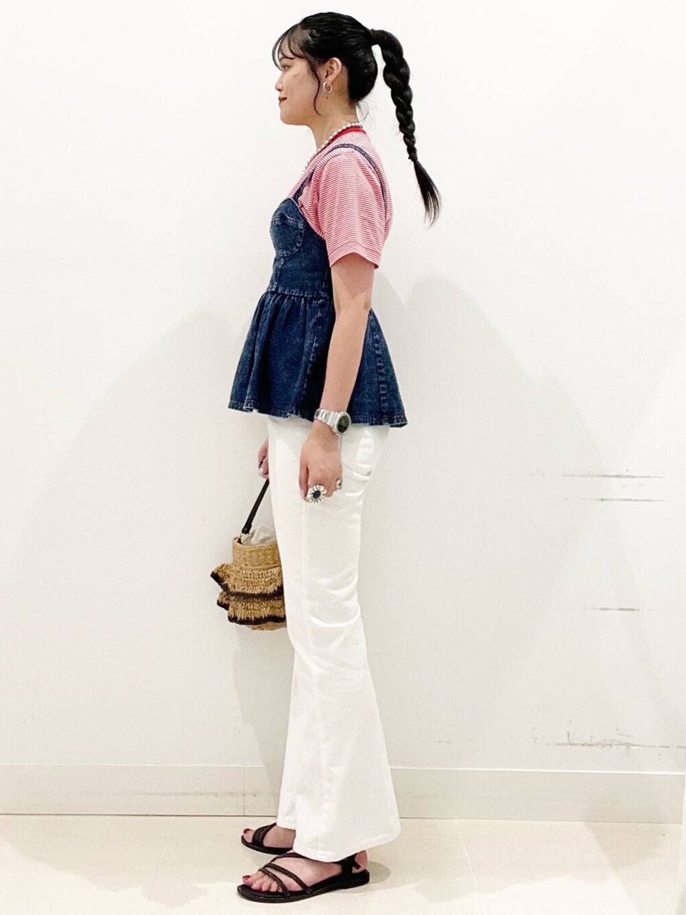ホワイト系のデニムパンツ、ブラック系のサンダル、ブルー系のベストを着用したレディースの夏コーディネートの5枚目の写真