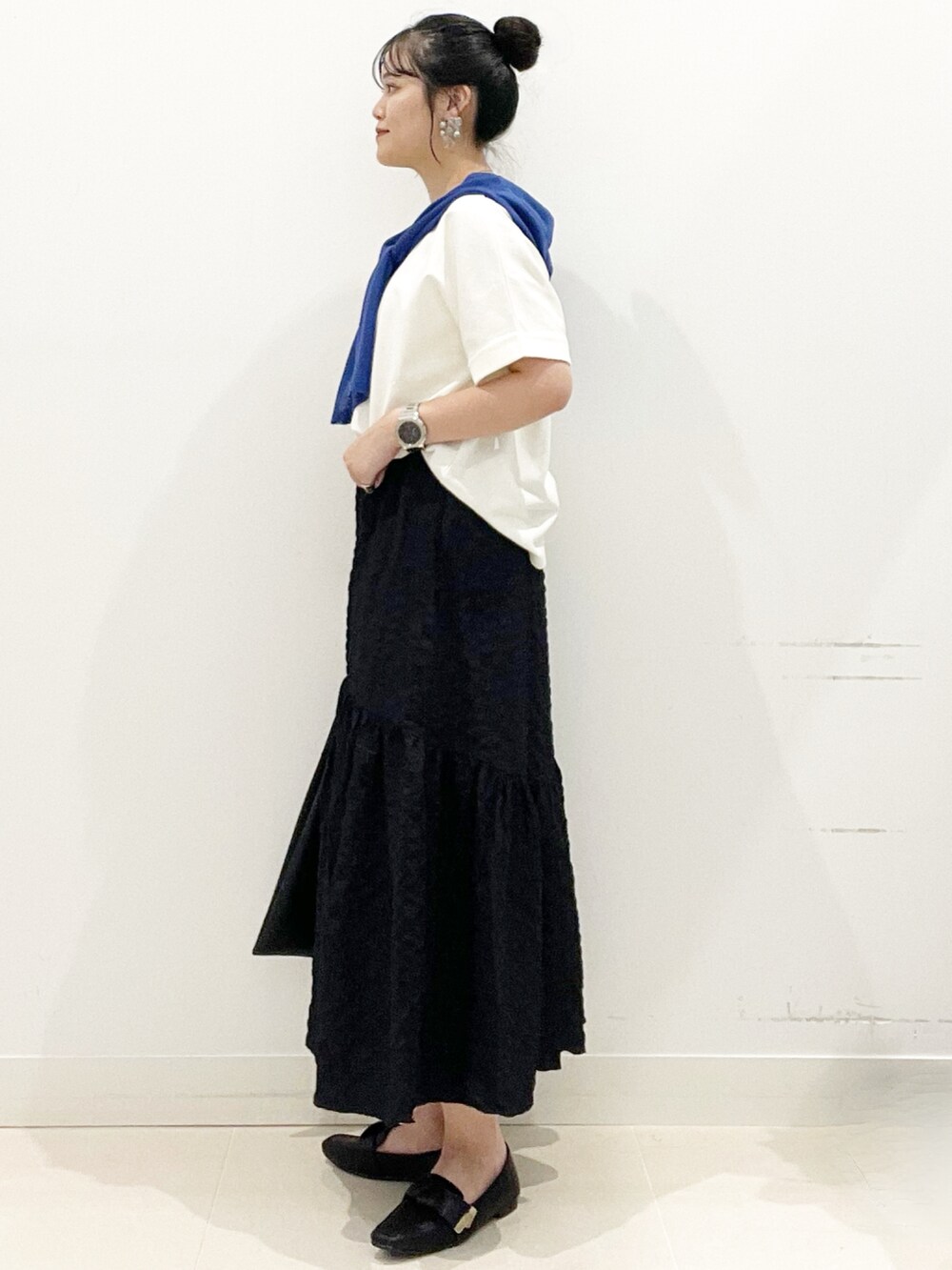 ブラック系のドレスシューズ、ブラック系のスカート、ホワイト系のTシャツ/カットソーを着用したレディースの夏コーディネートの4枚目の写真