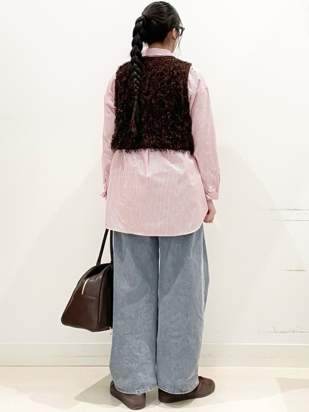 ブラウン系のスニーカー、ブルー系のデニムパンツ、ブラウン系のボストンバッグを着用したレディースの冬コーディネートの6枚目の写真