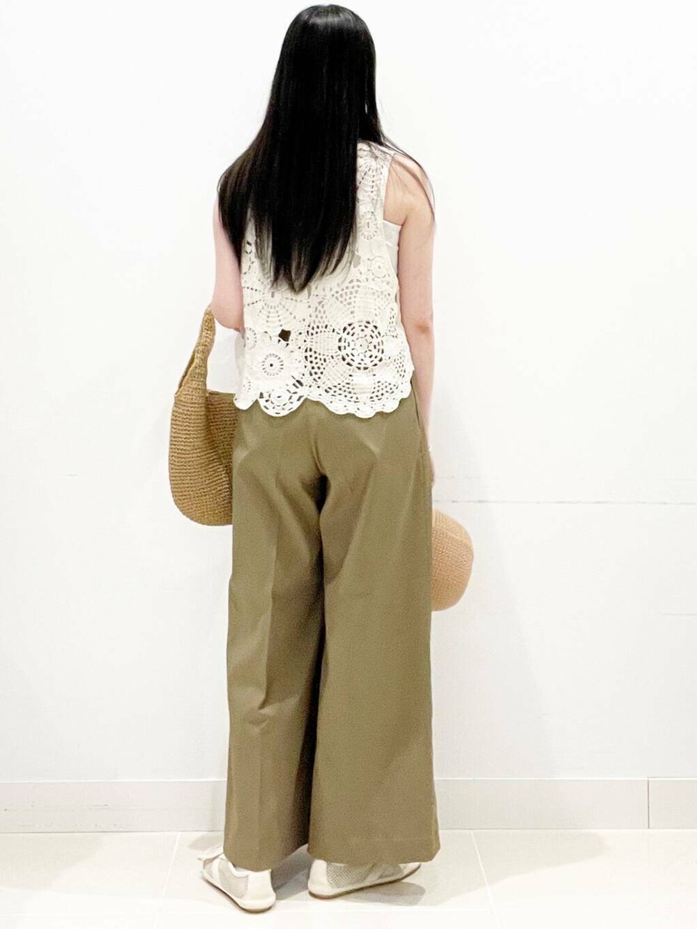 イエロー系のトートバッグ、ホワイト系のキャミソール、ホワイト系のベストを着用したレディースの夏コーディネートの7枚目の写真