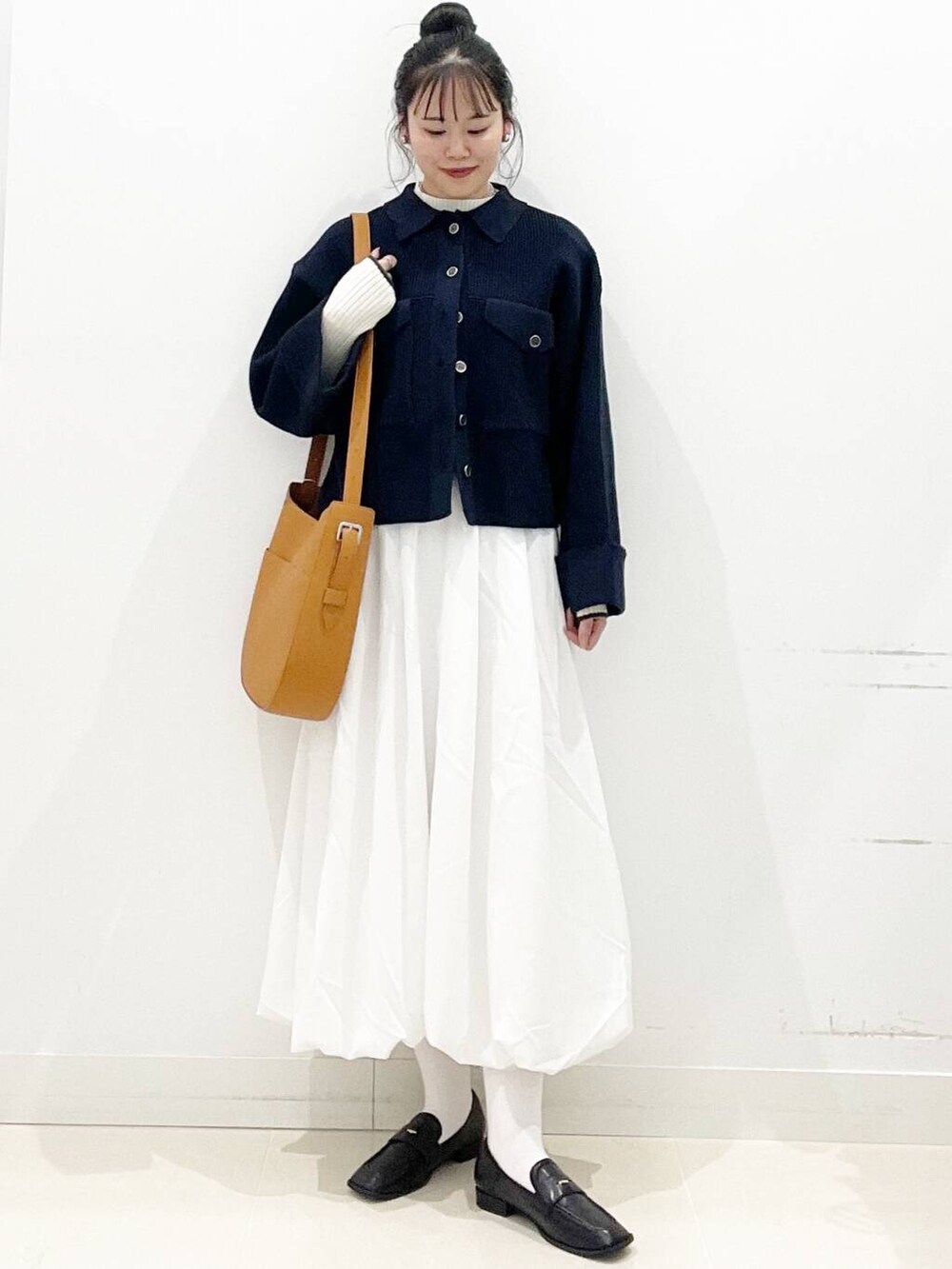 ホワイト系のスカート、ブラウン系のショルダーバッグ、ブラック系のローファーを着用したレディースの冬コーディネートの5枚目の写真