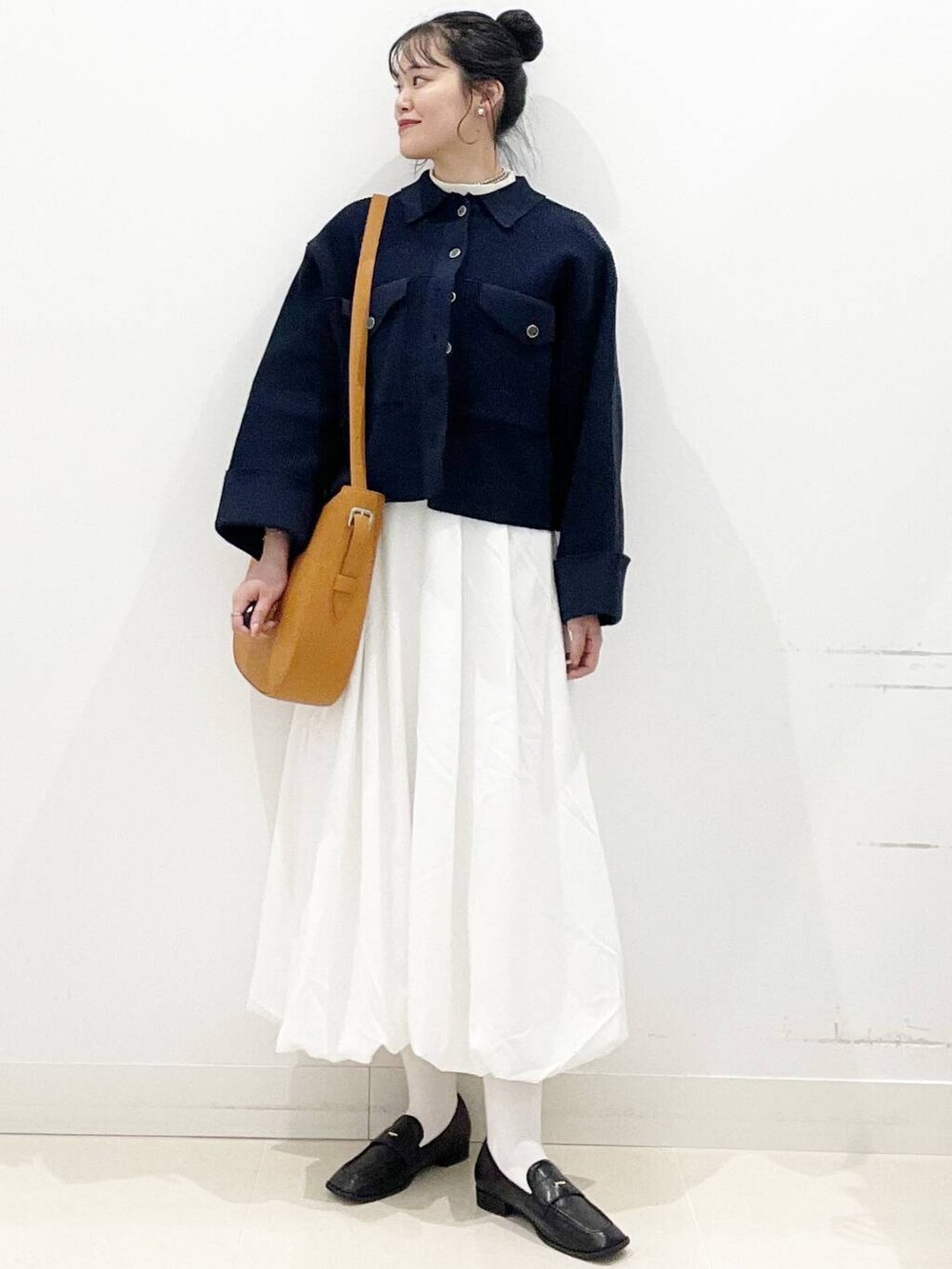 ホワイト系のスカート、ブラウン系のショルダーバッグ、ブラック系のローファーを着用したレディースの冬コーディネートの4枚目の写真