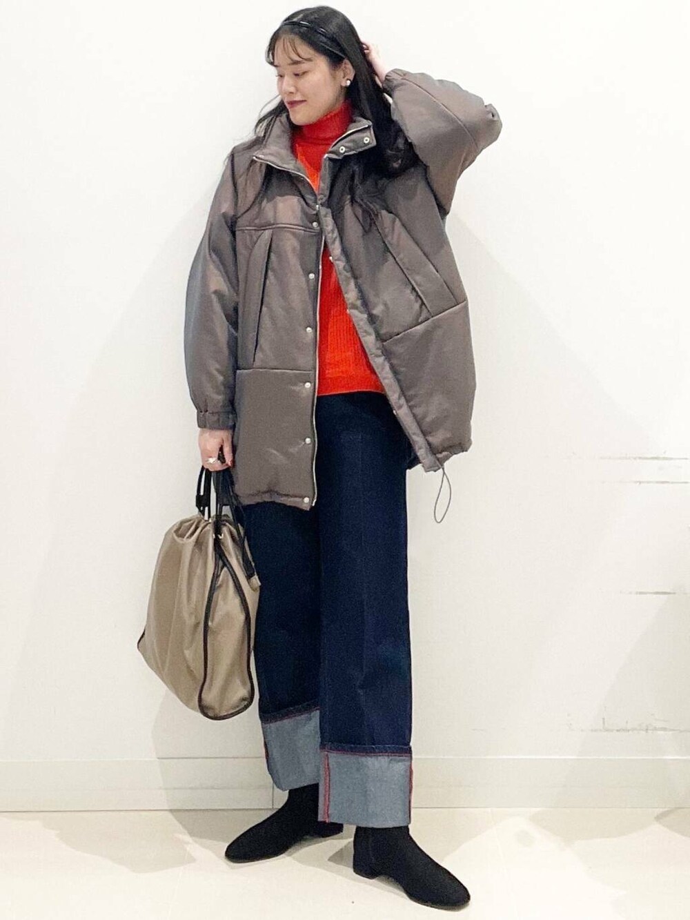 ブラック系のブーツ、レッド系のニット/セーター、ブルー系のデニムパンツを着用したレディースの冬コーディネートの3枚目の写真