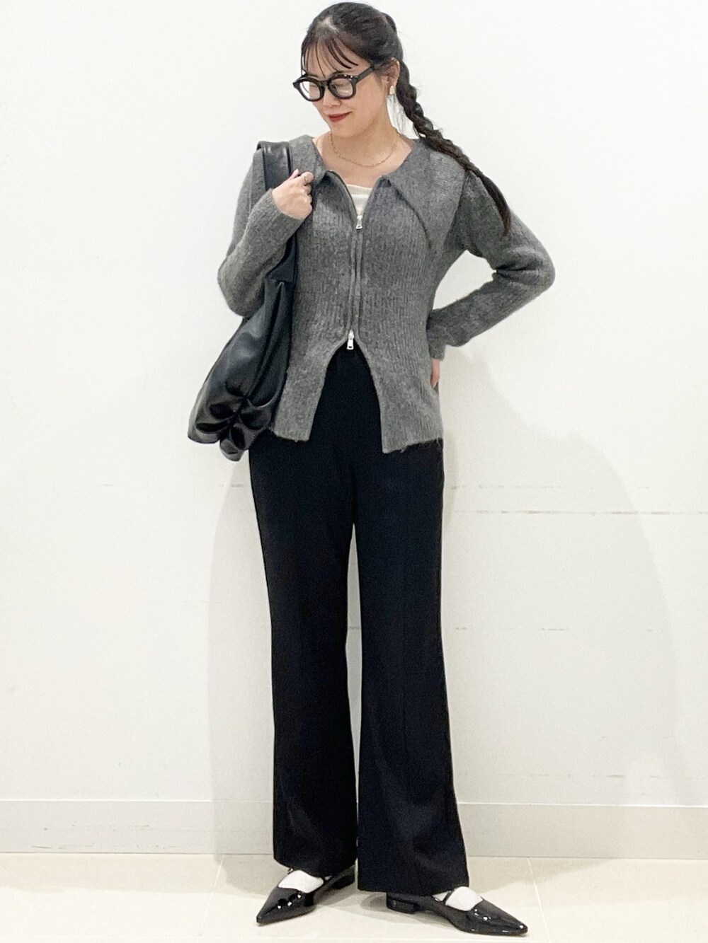 グレー系のカーディガン/ボレロ、ブラック系のパンプス、ホワイト系のTシャツ/カットソーを着用したレディースの冬コーディネートの3枚目の写真