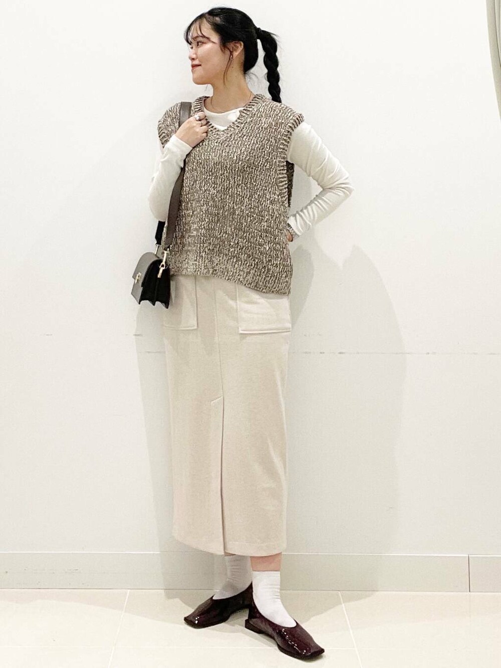 ブラウン系のショルダーバッグ、レッド系のバレエシューズ、ホワイト系のTシャツ/カットソーを着用したレディースの秋コーディネートの3枚目の写真