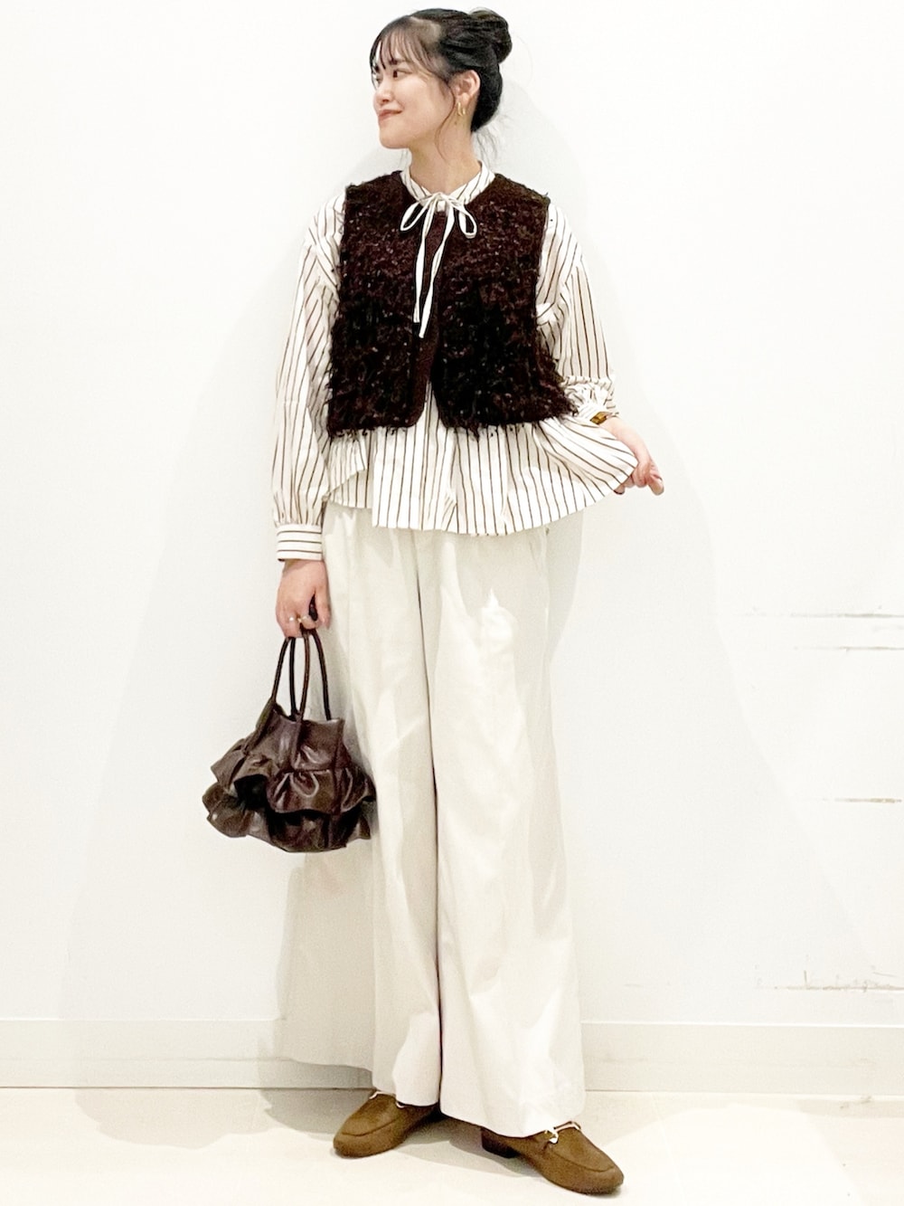 ホワイト系のその他パンツ、ブラウン系のハンドバッグ、イエロー系のローファーを着用したレディースの秋コーディネートの2枚目の写真