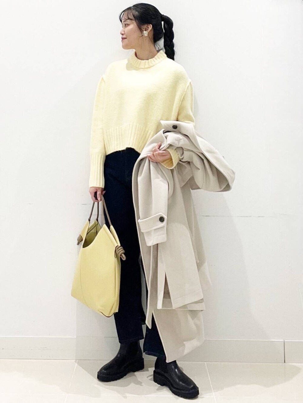 ブラック系のブーツ、ベージュ系のその他アウター、ブルー系のデニムパンツを着用したレディースの冬コーディネートの4枚目の写真