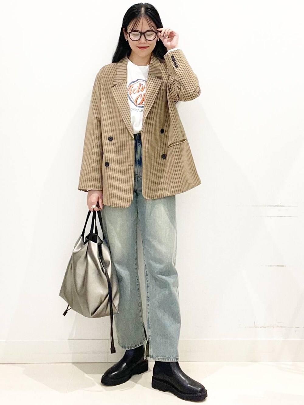 シルバー系のトートバッグ、ブルー系のその他パンツ、ブラック系のブーツを着用したレディースの秋コーディネートの2枚目の写真