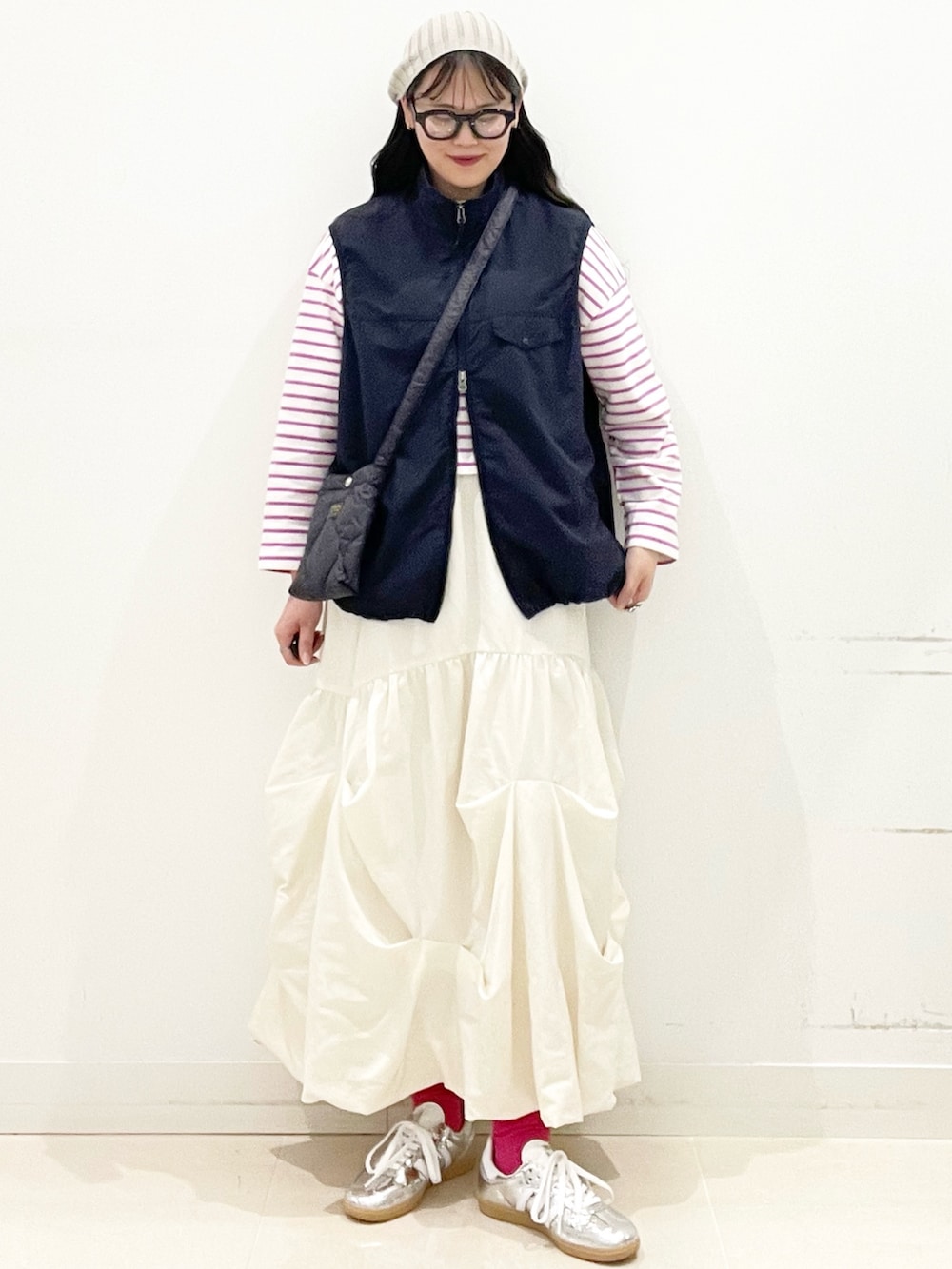 シルバー系のスニーカー、ホワイト系のスカート、ブルー系のナイロンジャケットを着用したレディースの春コーディネートの5枚目の写真