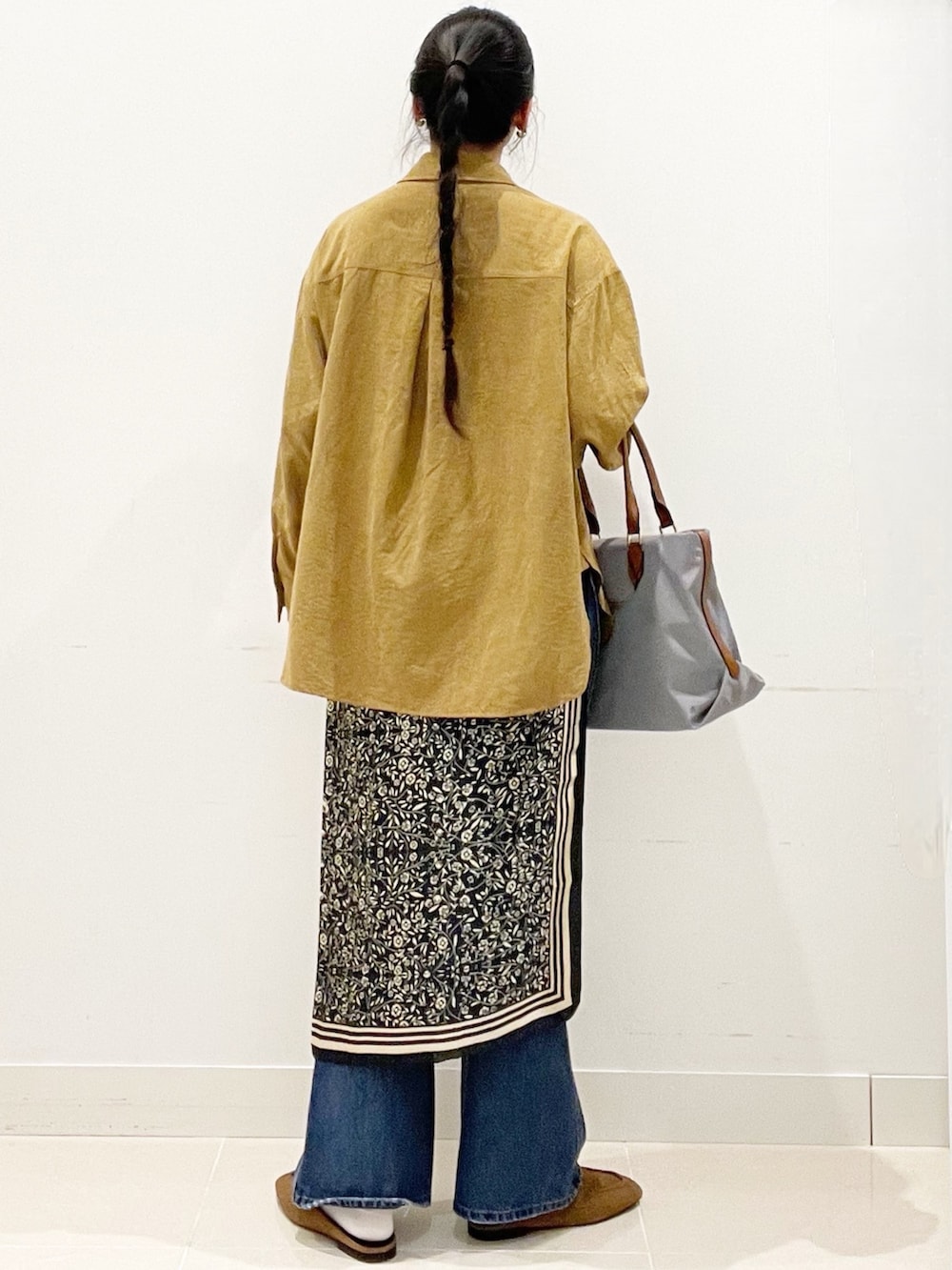 ブルー系のデニムパンツ、グレー系のトートバッグ、イエロー系のシャツ/ブラウスを着用したレディースの冬コーディネートの5枚目の写真