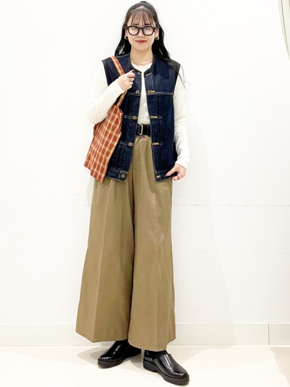 ベージュ系のその他パンツ、レッド系のトートバッグ、ホワイト系のTシャツ/カットソーを着用したレディースの秋コーディネートの3枚目の写真