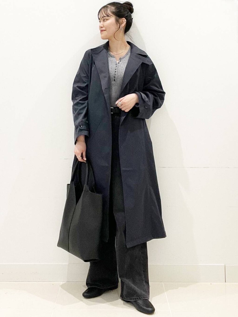 ブラック系のデニムパンツ、グレー系のニット/セーター、ブラック系のローファーを着用したレディースの春コーディネートの3枚目の写真