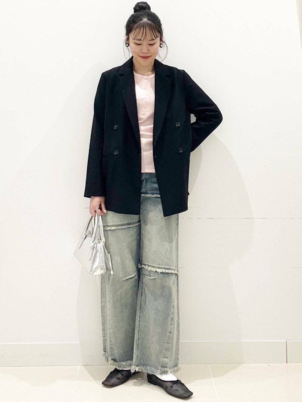 ブラック系のバレエシューズ、シルバー系のボストンバッグ、ブルー系のデニムパンツを着用したレディースの春コーディネートの4枚目の写真