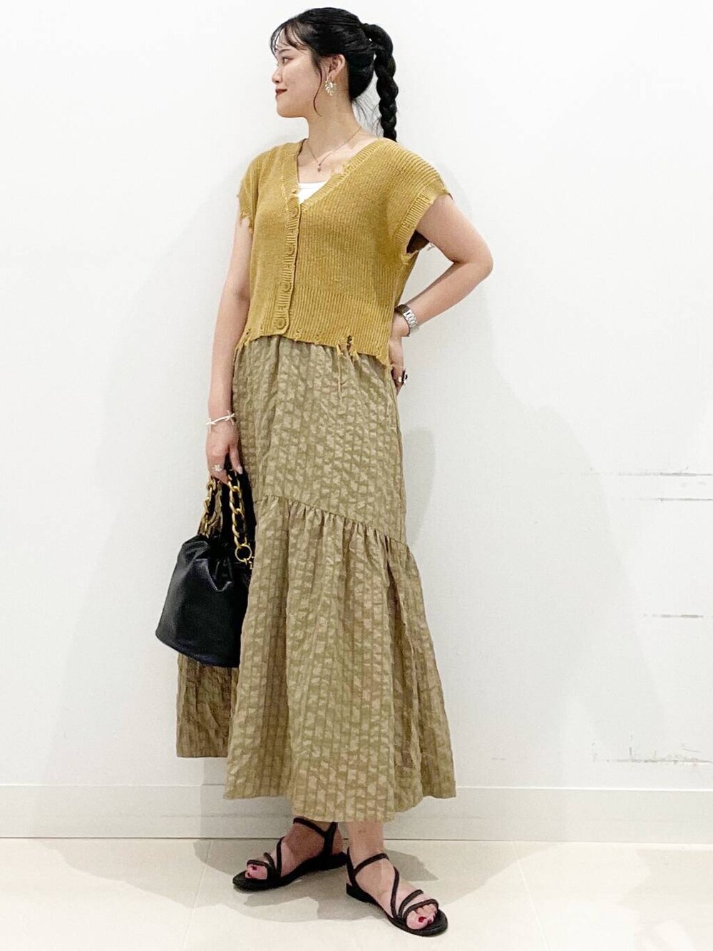 ホワイト系のキャミソール、グリーン系のスカート、ブラック系のサンダルを着用したレディースの夏コーディネートの3枚目の写真