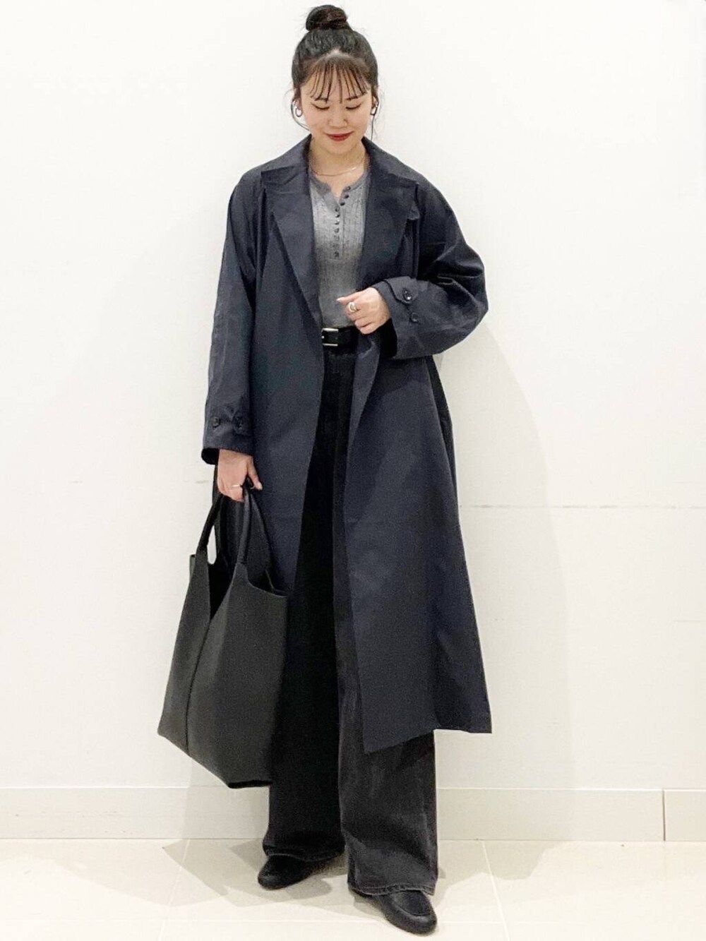 ブラック系のデニムパンツ、グレー系のニット/セーター、ブラック系のローファーを着用したレディースの春コーディネートの4枚目の写真