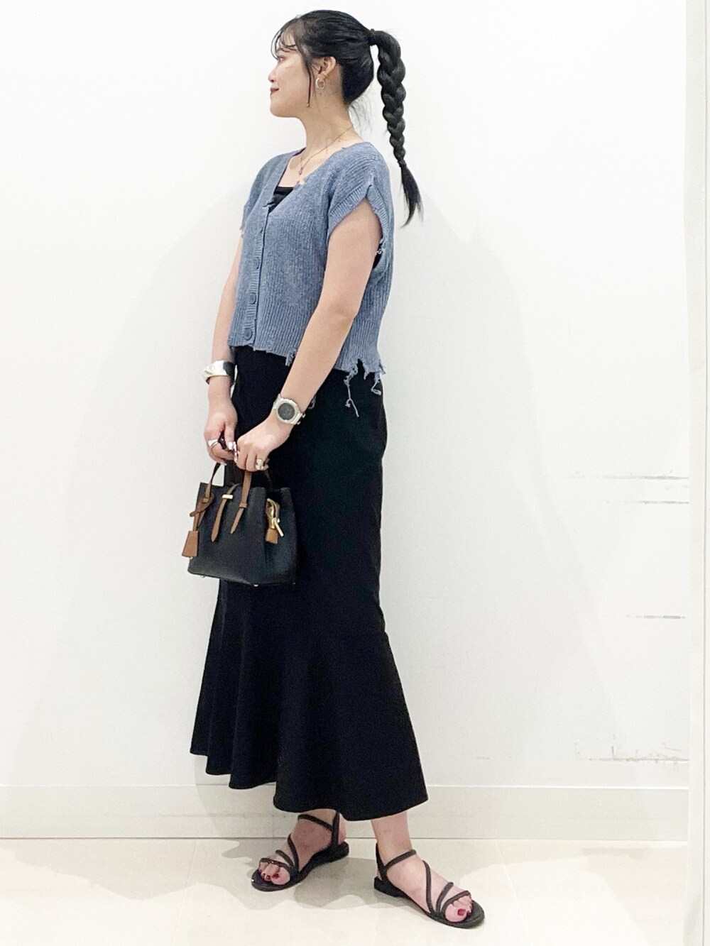 ブラック系のハンドバッグ、ブラック系のキャミソール、ブラック系のサンダルを着用したレディースの夏コーディネートの5枚目の写真