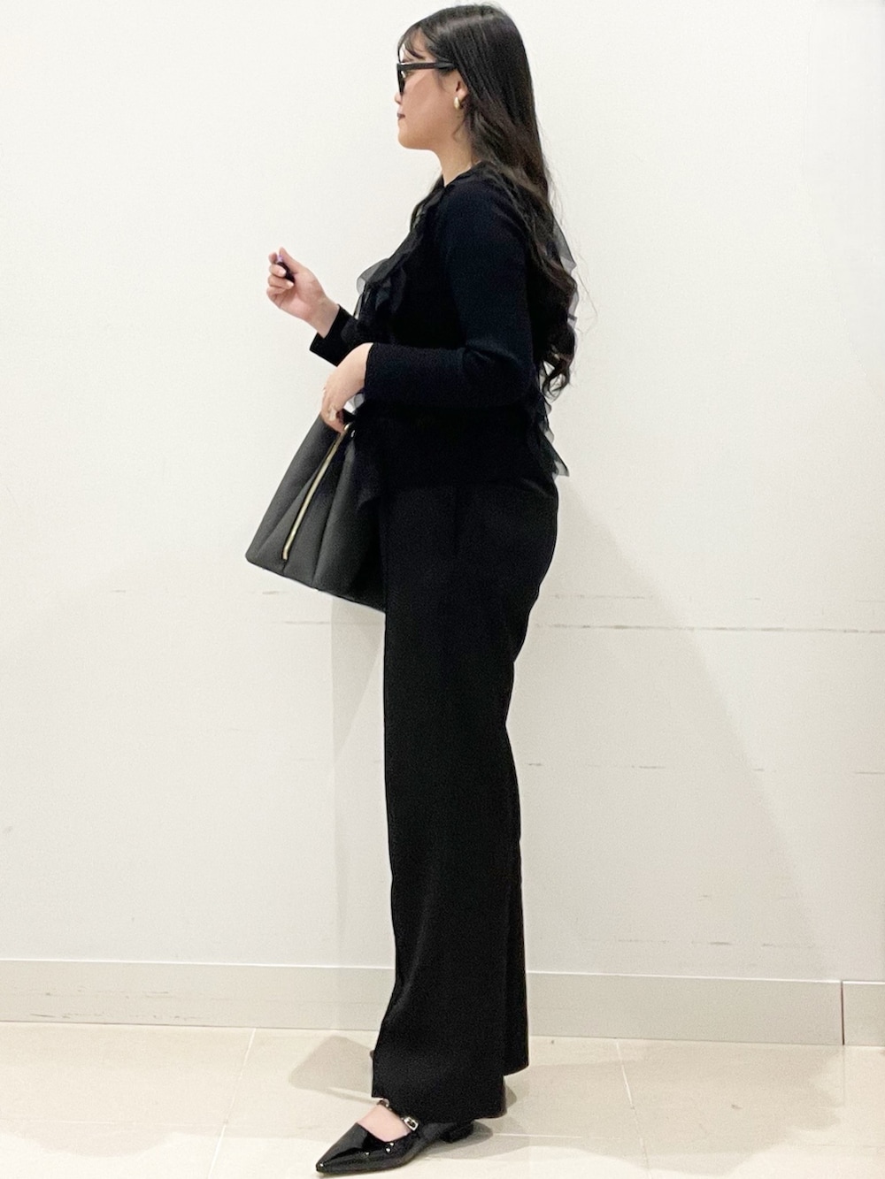 ブラック系のパンプス、ブラック系のトートバッグ、ブラック系のキャミソールを着用したレディースの冬コーディネートの4枚目の写真