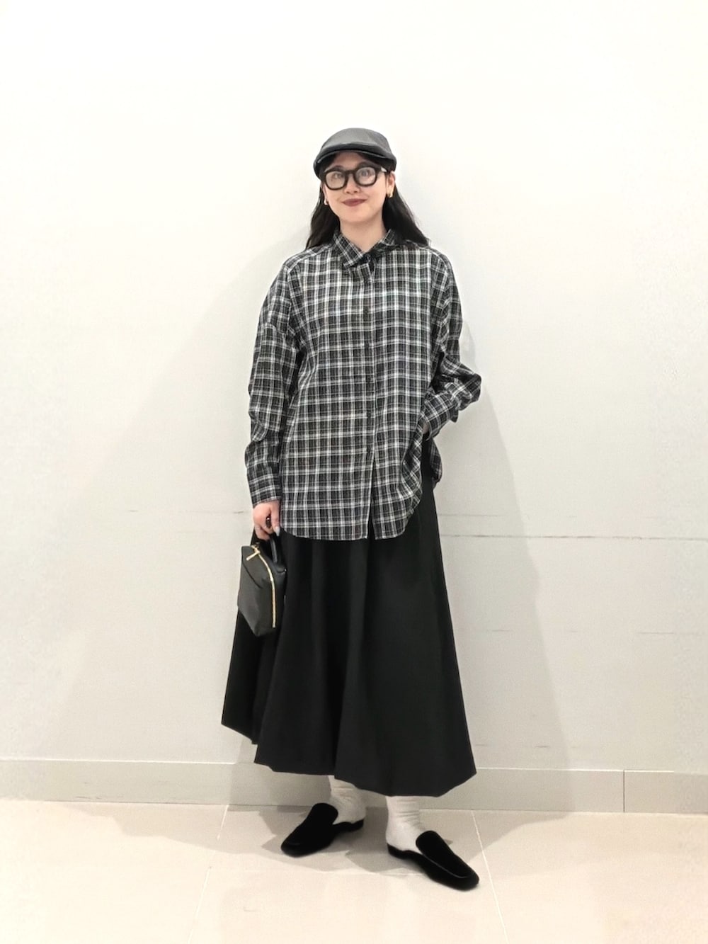 ブラック系のシャツ/ブラウス、ブラック系のスカート、ブラック系のショルダーバッグを着用したレディースの秋コーディネートの2枚目の写真