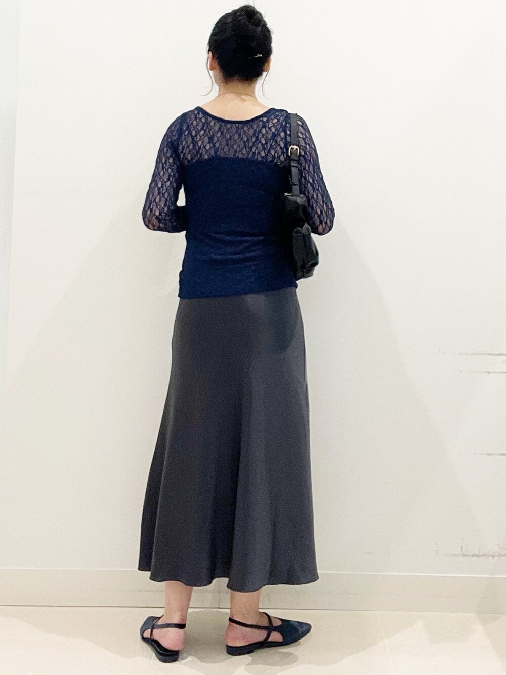 ブラック系のキャミソール、ブラック系のハンドバッグ、ブルー系のパンプスを着用したレディースの秋コーディネートの7枚目の写真