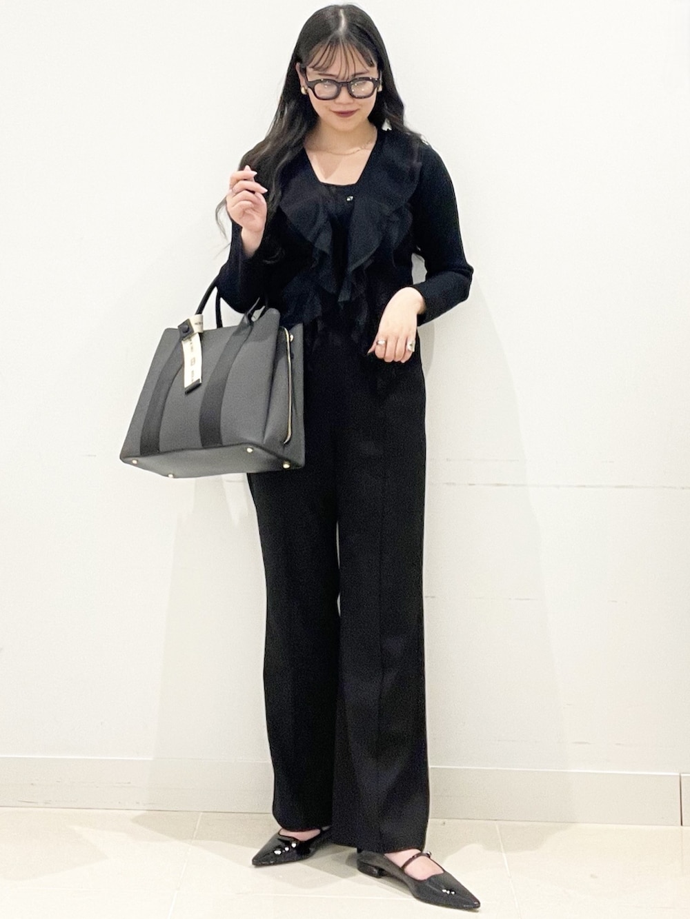 ブラック系のパンプス、ブラック系のトートバッグ、ブラック系のキャミソールを着用したレディースの冬コーディネートの3枚目の写真