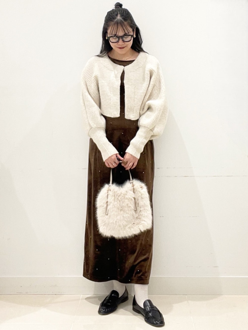 ホワイト系のショルダーバッグ、ブラウン系のワンピース、ベージュ系のニット/セーターを着用したレディースの冬コーディネートの3枚目の写真