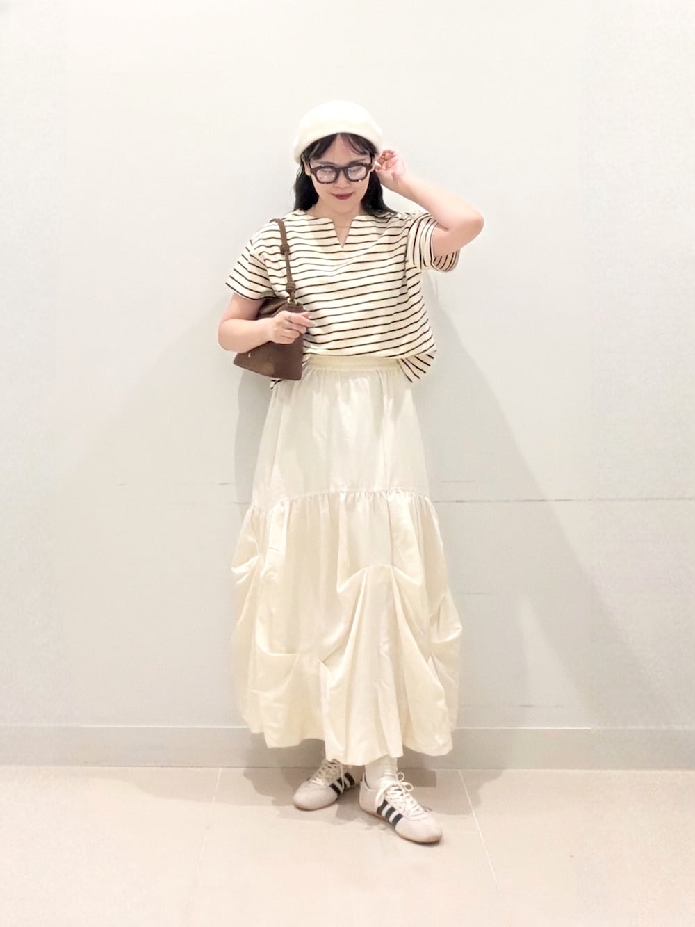 ホワイト系のTシャツ/カットソー、ホワイト系のスカート、ホワイト系のスニーカーを着用したレディースの夏コーディネートの2枚目の写真