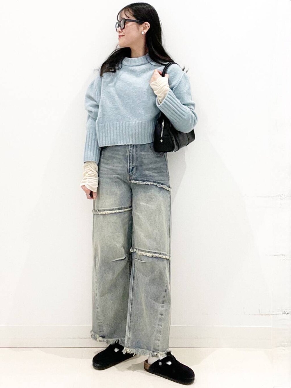 ブラック系のボストンバッグ、ブラック系のサンダル、ブルー系のニット/セーターを着用したレディースの冬コーディネートの3枚目の写真