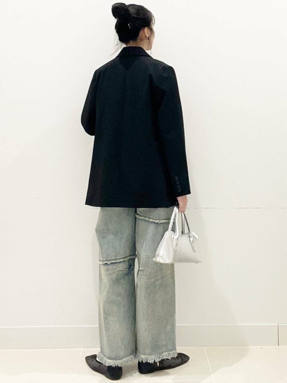 ブラック系のバレエシューズ、シルバー系のボストンバッグ、ブルー系のデニムパンツを着用したレディースの春コーディネートの6枚目の写真