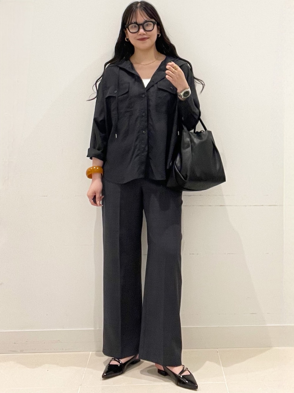 ブラック系のパンプス、グレー系のその他パンツ、ブラック系のショルダーバッグを着用したレディースの春コーディネートの3枚目の写真