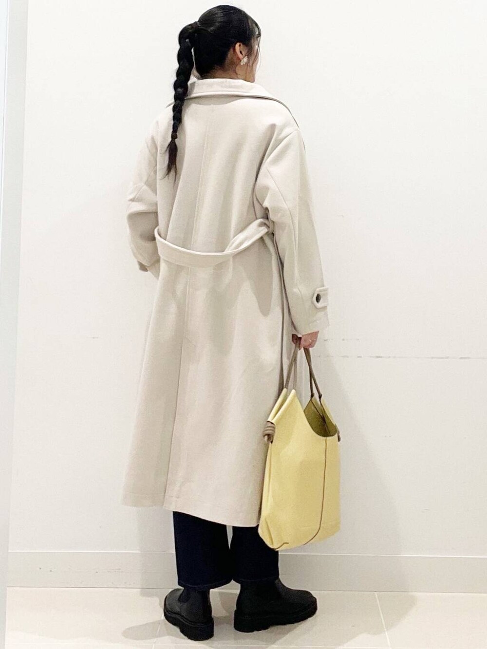 ブラック系のブーツ、ベージュ系のその他アウター、ブルー系のデニムパンツを着用したレディースの冬コーディネートの7枚目の写真