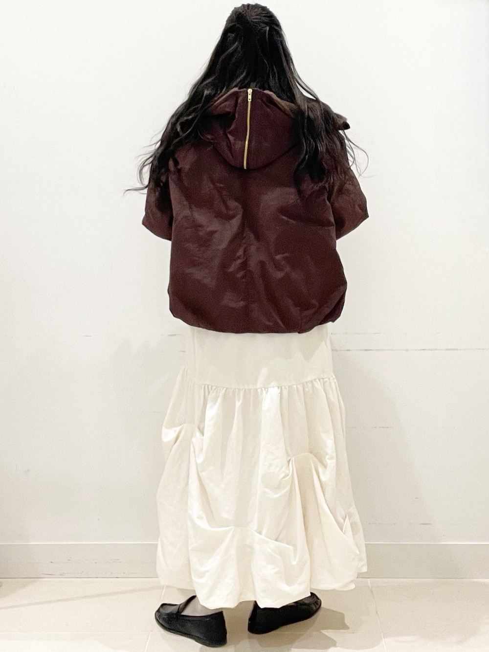 ホワイト系のスカート、ブラック系のボストンバッグ、ブルー系のニット/セーターを着用したレディースの冬コーディネートの2枚目の写真