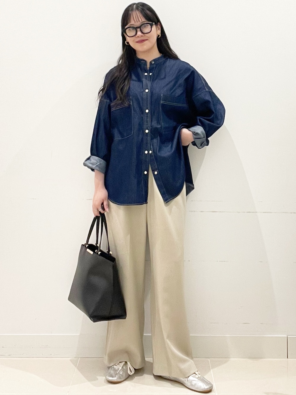 ベージュ系のスラックス、ブラック系のトートバッグ、ブルー系のシャツ/ブラウスを着用したレディースの春コーディネートの4枚目の写真