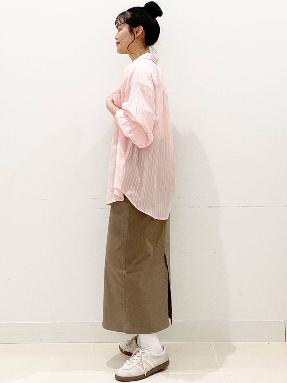 ホワイト系のスニーカー、ブラウン系のスカート、ホワイト系のキャミソールを着用したレディースの春コーディネートの6枚目の写真