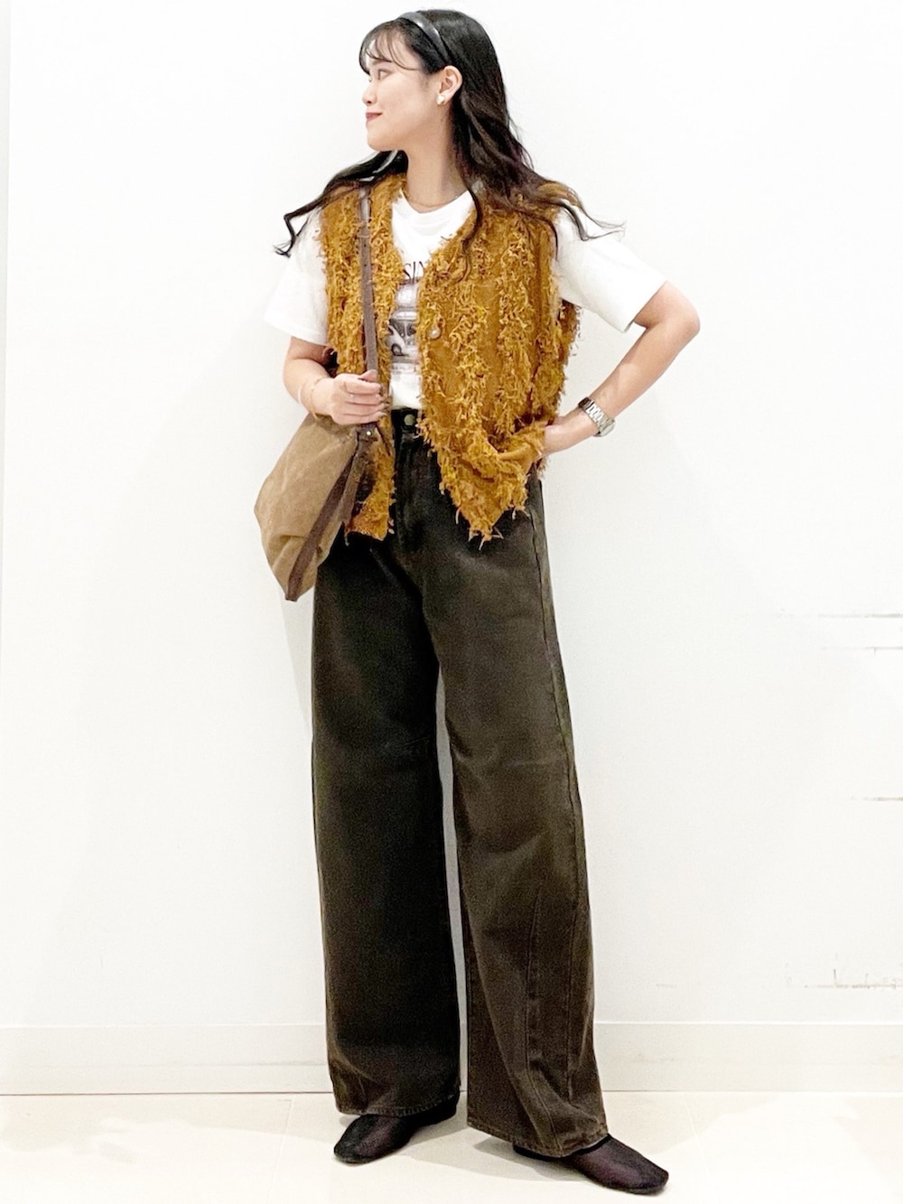 ブラック系のバレエシューズ、ブラウン系のデニムパンツ、ブラウン系のショルダーバッグを着用したレディースの秋コーディネートの2枚目の写真