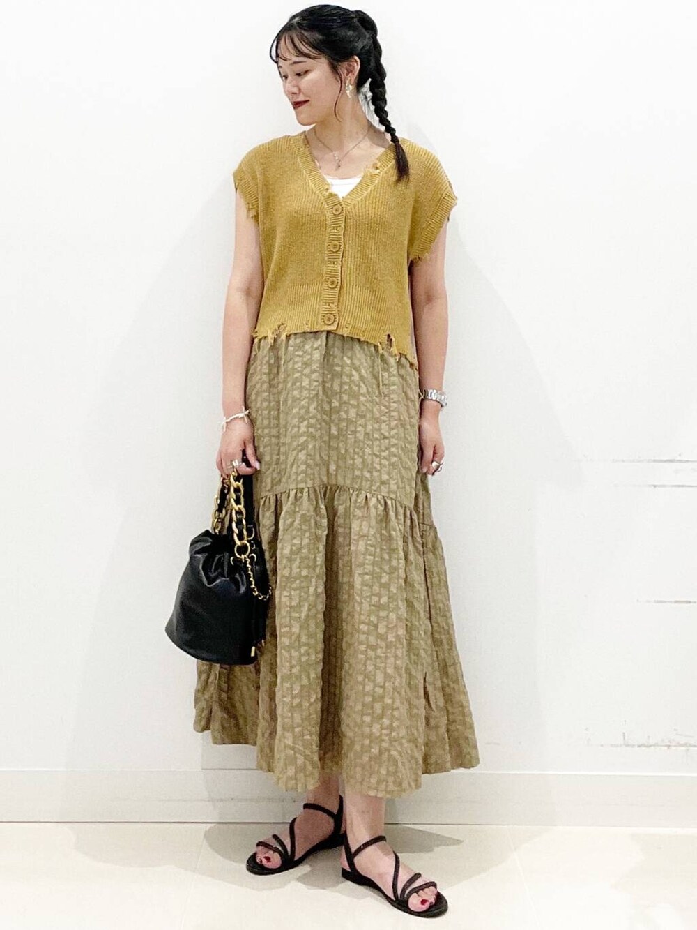 ホワイト系のキャミソール、グリーン系のスカート、ブラック系のサンダルを着用したレディースの夏コーディネートの6枚目の写真