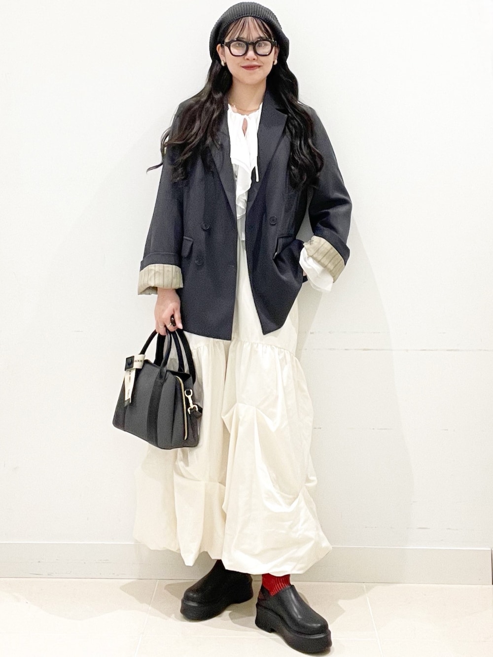 ブラック系のその他シューズ、ブラック系のハンドバッグ、ホワイト系のスカートを着用したレディースの冬コーディネートの2枚目の写真