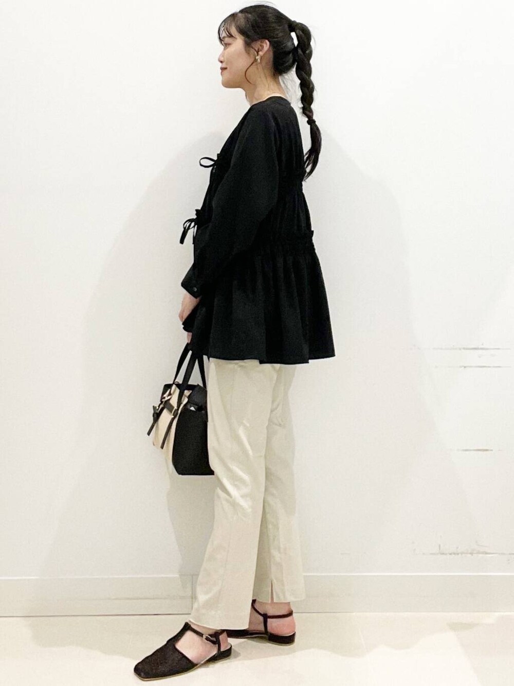 ベージュ系のその他パンツ、ブラック系のトートバッグ、ブラック系のキャミソールを着用したレディースの春コーディネートの5枚目の写真
